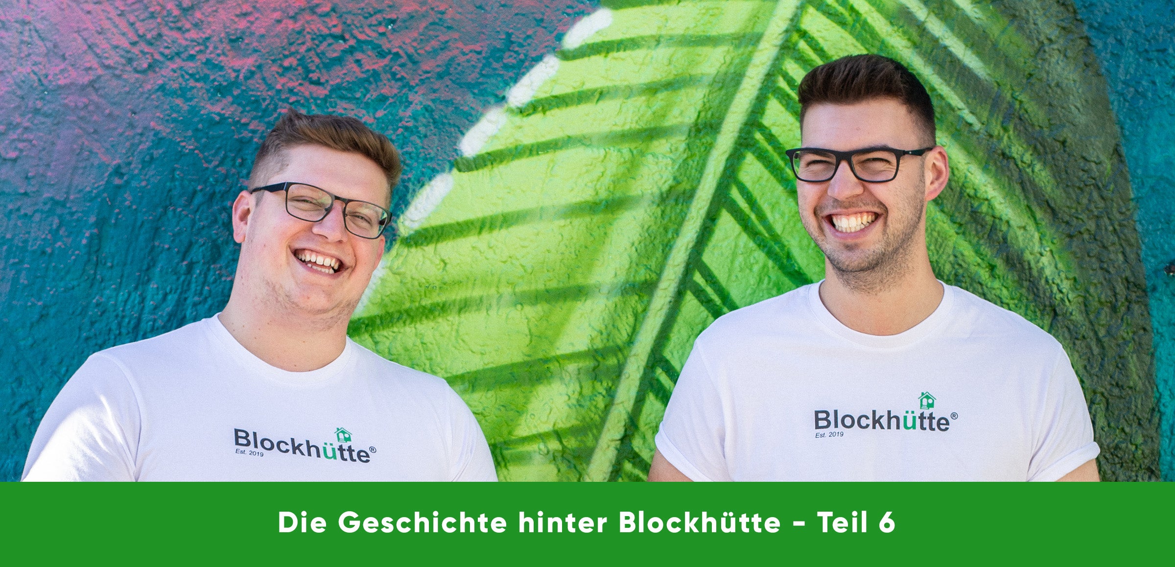 Nils und Malte, die Gründer von Blockhütte, gemeinsam lachend vor einer Wand